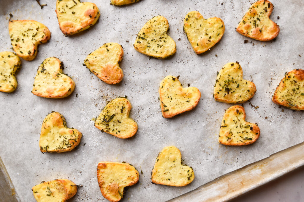 Roasted heart shaped potatoes on a baking sheet for Valentine's Day meal